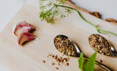 garlic cloves spices and herbs on stainless spoons